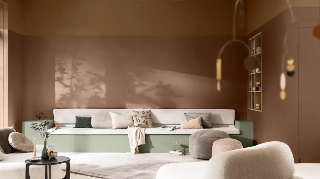 Dulux 2027 Glow living room with warm terracotta walls and sage green seating